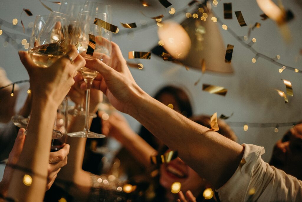 Glasses raised as gold confetti rains down