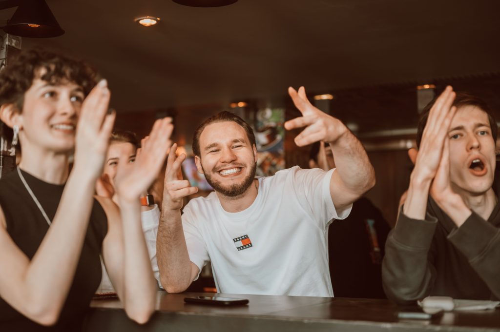 A competitive group smile and cheer while playing trivia