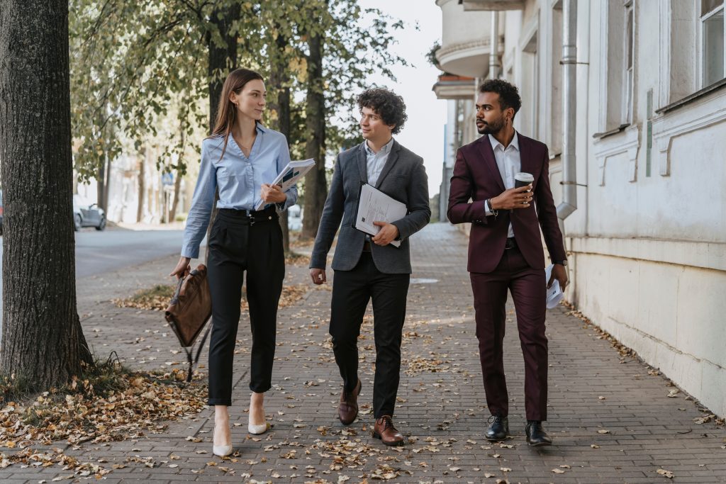 A trio of office workers out on the sidewalk in the fall.